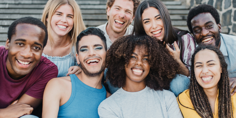 Young group of people smiling on camera having fun outdoor in the city - Focus on african girl face